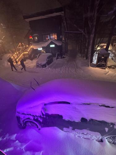 a car is covered in purple lights in the snow at SuiShou in Kutchan