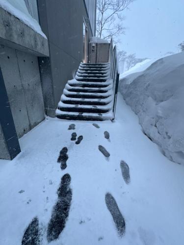 a group of footprints in the snow next to a building at SuiShou in Kutchan
