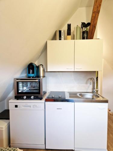 a small kitchen with a microwave and a sink at ARGENTA Living 15 in Fulda