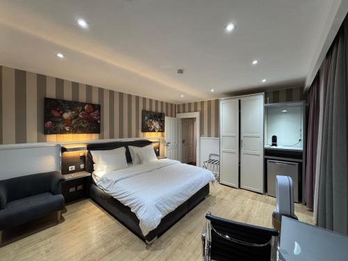 a bedroom with a bed and a chair and a television at Résidence des Fleurs in Hombourg-Haut