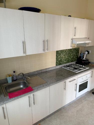 a kitchen with white cabinets and a sink at Appartement tangier airport in Tangier