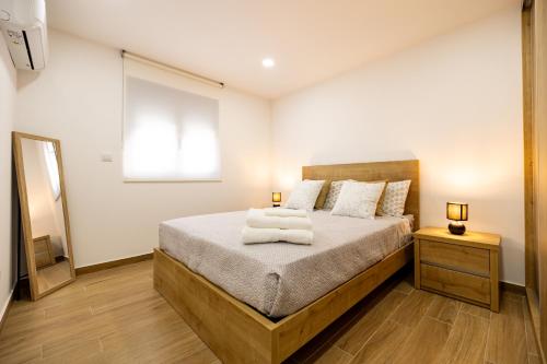 a bedroom with a bed with two lamps and a window at Casa no cimo do Douro in Loureiro
