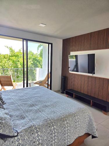 a bedroom with a large bed and a flat screen tv at Burgos Cuernavaca Pool Terrace & Garden in Temixco