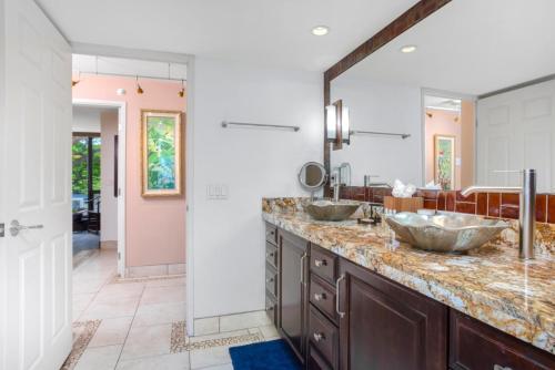 a bathroom with two sinks and a large mirror at Mahana by KBM Resorts in Kaanapali
