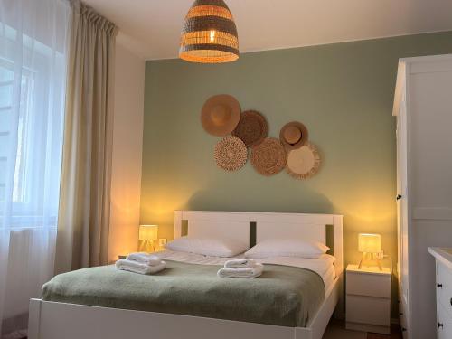 a bedroom with a bed with two towels on it at City Center & Free Parking - Rest & Nest Boho Deluxe Apartment in Debrecen