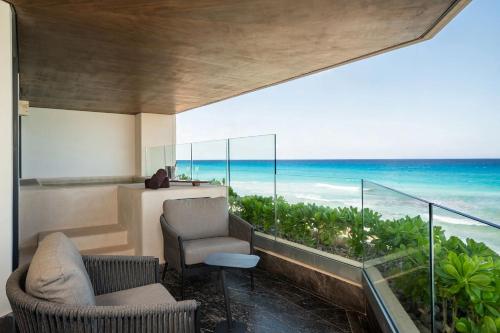 a room with a balcony with a view of the ocean at Secrets Mirabel Cancún Resort & Spa in Cancún