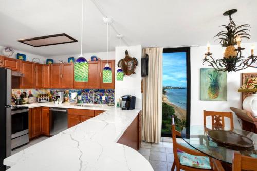 a kitchen with a counter top and a table at Mahana by KBM Resorts in Kaanapali