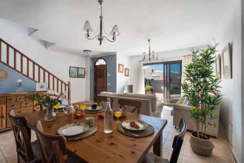 a dining room and living room with a table and chairs at Sunhouse El Chocito in Candelaria