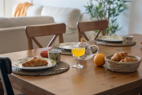 a wooden table with plates of food and orange juice at Sunhouse El Chocito in Candelaria