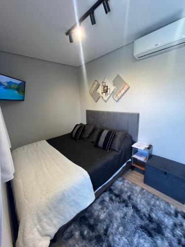 a bedroom with a bed in a room with a projector at Chalés São Roque Studios in São Roque