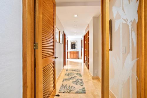 a hallway with a door and a rug on the floor at Mahana by KBM Resorts in Kaanapali