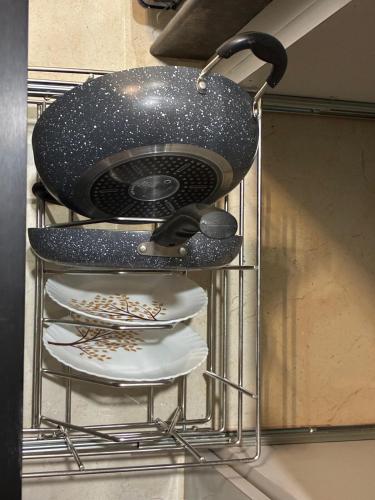 a metal shelf with plates and a pot on top at Zen Den Luxury Hill Villa for a Peaceful Escape in Pune