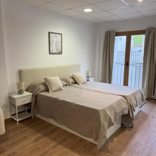 a bedroom with a bed and a large window at Med Time Hotel Boutique in Calpe