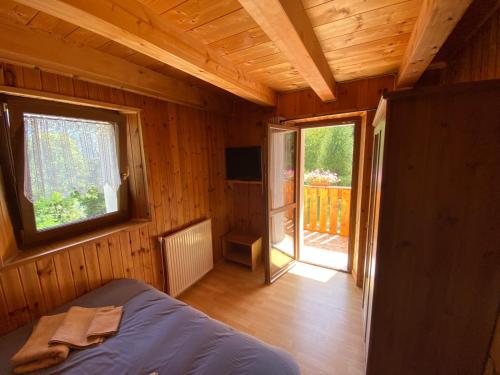 a bedroom with a bed and a window and a television at Le porte dell'agordino in Zenich
