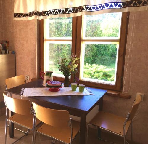 a dining room table with chairs and a window at Paadi puhkemaja in Salinõmme