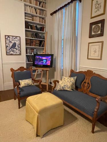a living room with two chairs and a television at Chesnut Cottage Inn in Columbia