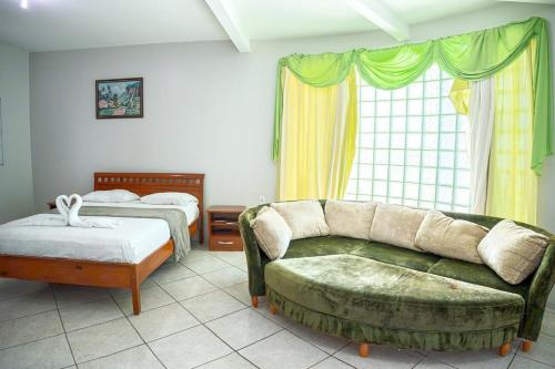 a living room with a couch and a bed at Swamy Hotel in Cruzeiro do Sul