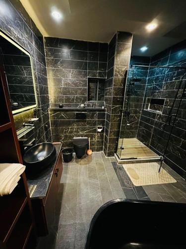 a bathroom with a shower with a sink and a tub at Nova rise apartments in Ibeju