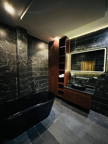 a bathroom with a black tub and a sink at Nova rise apartments in Ibeju