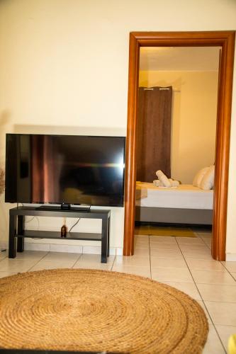 a living room with a television and a mirror at Gk Suites-Constantin view , auto check-in 24h in Larisa