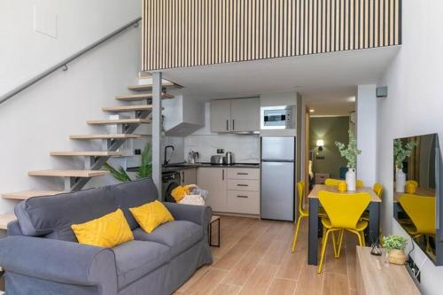 a living room with a blue couch and a kitchen at NUEVO Amplio dúplex en la zona del Palacio de Vista Alegre in Madrid
