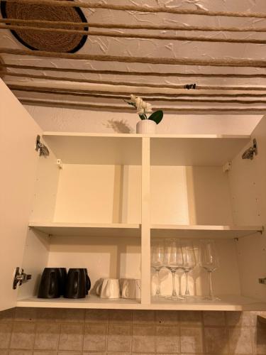 a white cabinet with wine glasses on it at myna in Thale