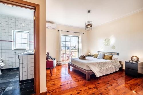 a bedroom with a bed and a bathroom at Da Rocha House in Parchal