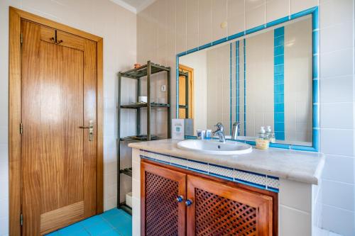 a bathroom with a sink and a mirror at Da Rocha House in Parchal