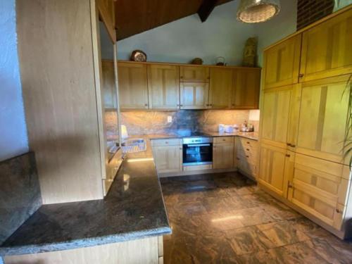 a kitchen with wooden cabinets and a stove top oven at Boogie House in Dochamps