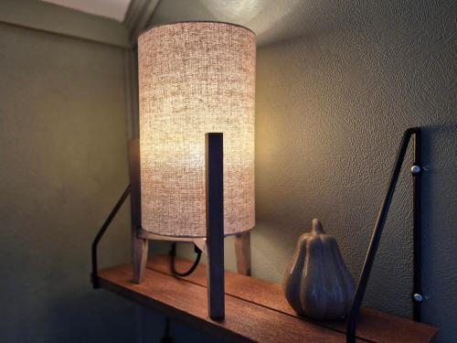 a lamp on a shelf with a vase on it at Trines Hjerterom in Steinkjer