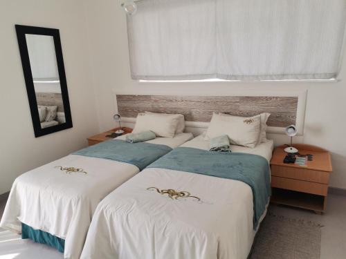 two beds sitting next to each other in a bedroom at Guesthouse Terra Africa in Windhoek