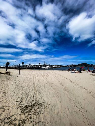 a group of people sitting on a sandy beach at Praia do Canto Apart Hotel - Vista para o Mar 102A in Vitória