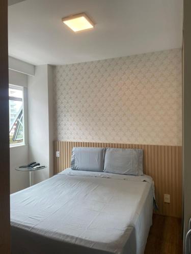 a bedroom with a bed and a wall at Praia do canto Apart Hotel - Apto 203 Varanda Lateral com Vista Mar in Vitória