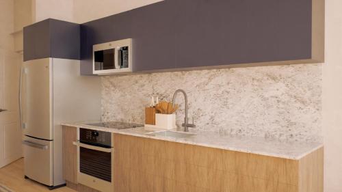 a kitchen with a sink and a refrigerator at Flow Brickell Hotel in Miami