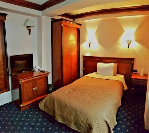 a hotel room with a bed and a television at ANGELS View in Skopje
