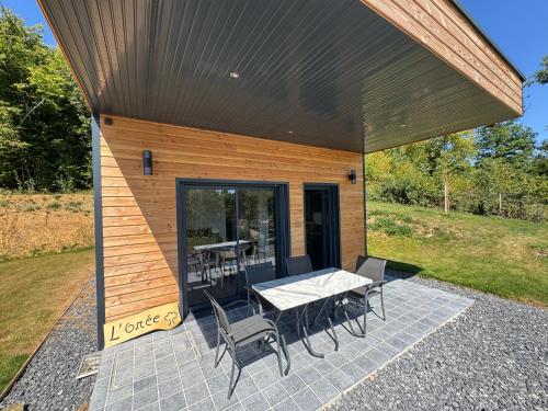 a house with a table and chairs on a patio at L'Orée Lodge in Montcornet