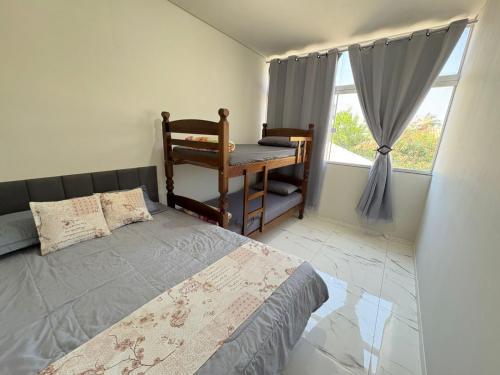 a bedroom with a bed and a desk and a window at Casa Temporada Aconchego e tranquilidade 1 in Bonito