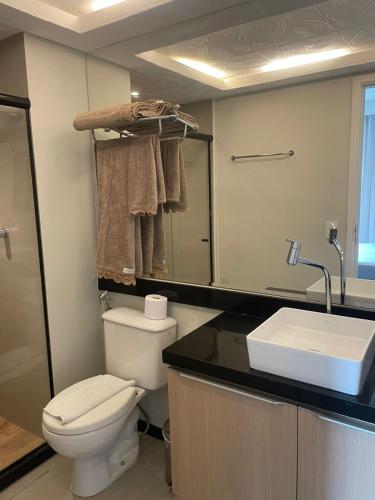 a bathroom with a toilet and a sink at Praia do canto Apart Hotel - Apto 203 Varanda Lateral com Vista Mar in Vitória