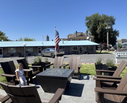 a little girl standing next to a table and chairs at Bridge Street Inn in Baker City