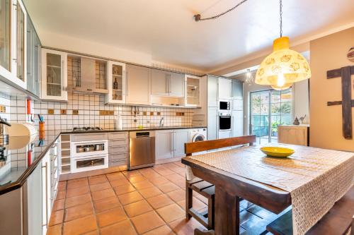 a kitchen with a wooden table and a dining room at Da Rocha House in Parchal