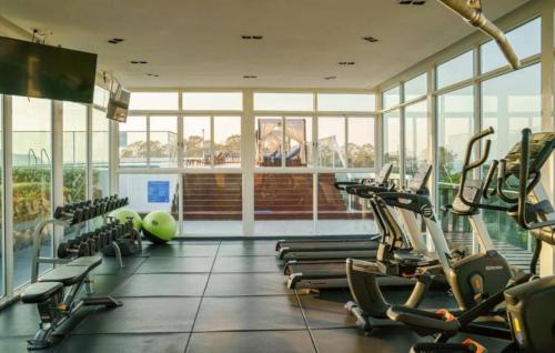 a gym with rows of treadmills and elliptical machines at Sea saran Condominium - Modern & nature Studio in Bang Sare