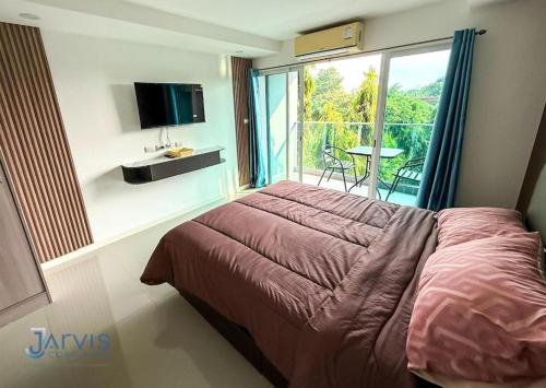 Un dormitorio con una cama grande y un balcón. en Sea saran Condominium - Modern & nature Studio, en Bang Sare