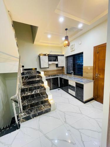 a large kitchen with a staircase in a room at Cozy & comfy House in Rawalpindi