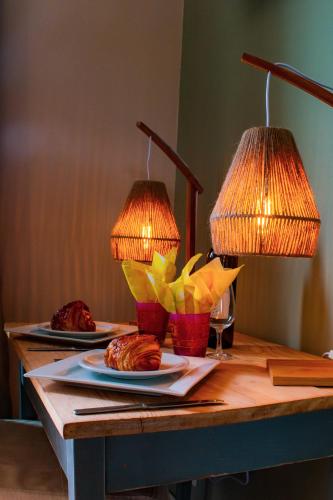 two plates of food on a table with two lamps at Chambre Henriette in Incourt