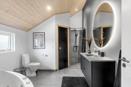 a bathroom with a sink and a toilet and a mirror at M184-Vaeggerlose-Kaninstien-41 in Bøtø By