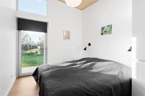 a bedroom with a bed and a large window at M14010-Vaeggerlose-Savavej-29 in Marielyst