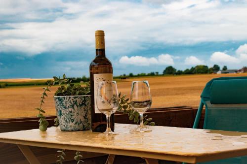 a bottle of wine sitting on a table with two glasses at Chambre Henriette in Incourt