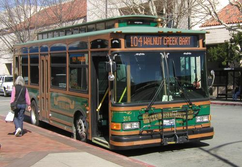 a green bus parked on the side of a street at Downtown-King Bed-Top Floor-Parking-Wi-Fi in Walnut Creek