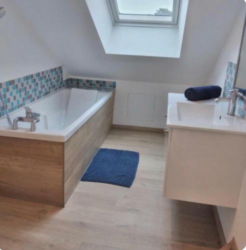 a bathroom with a large tub and a sink at VILLA 1900 Bord de mer piscine SPA Nordique in Saint-Brevin-les-Pins