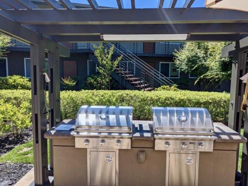 twourgers on a grill under a pergola at Downtown-King Bed-Top Floor-Parking-Wi-Fi in Walnut Creek